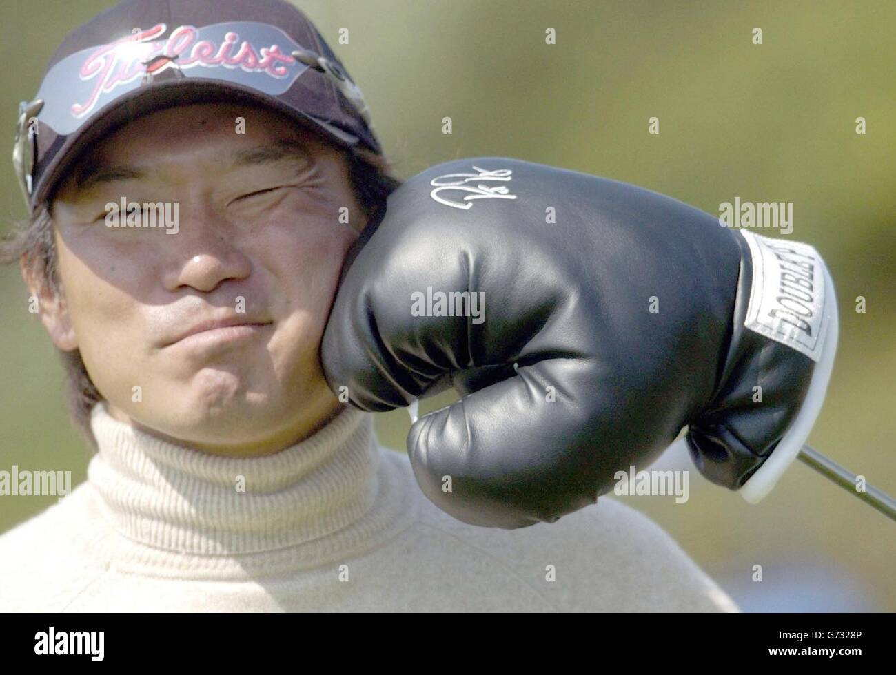 Japan's Yoshinobu Tsukada has some fun with his golf club cover, a boxing glove, held by his caddie, during a practice round for the 133rd Open Championship at Royal Troon Golf Club, Scotland. NO MOBILE PHONE USE Stock Photo
