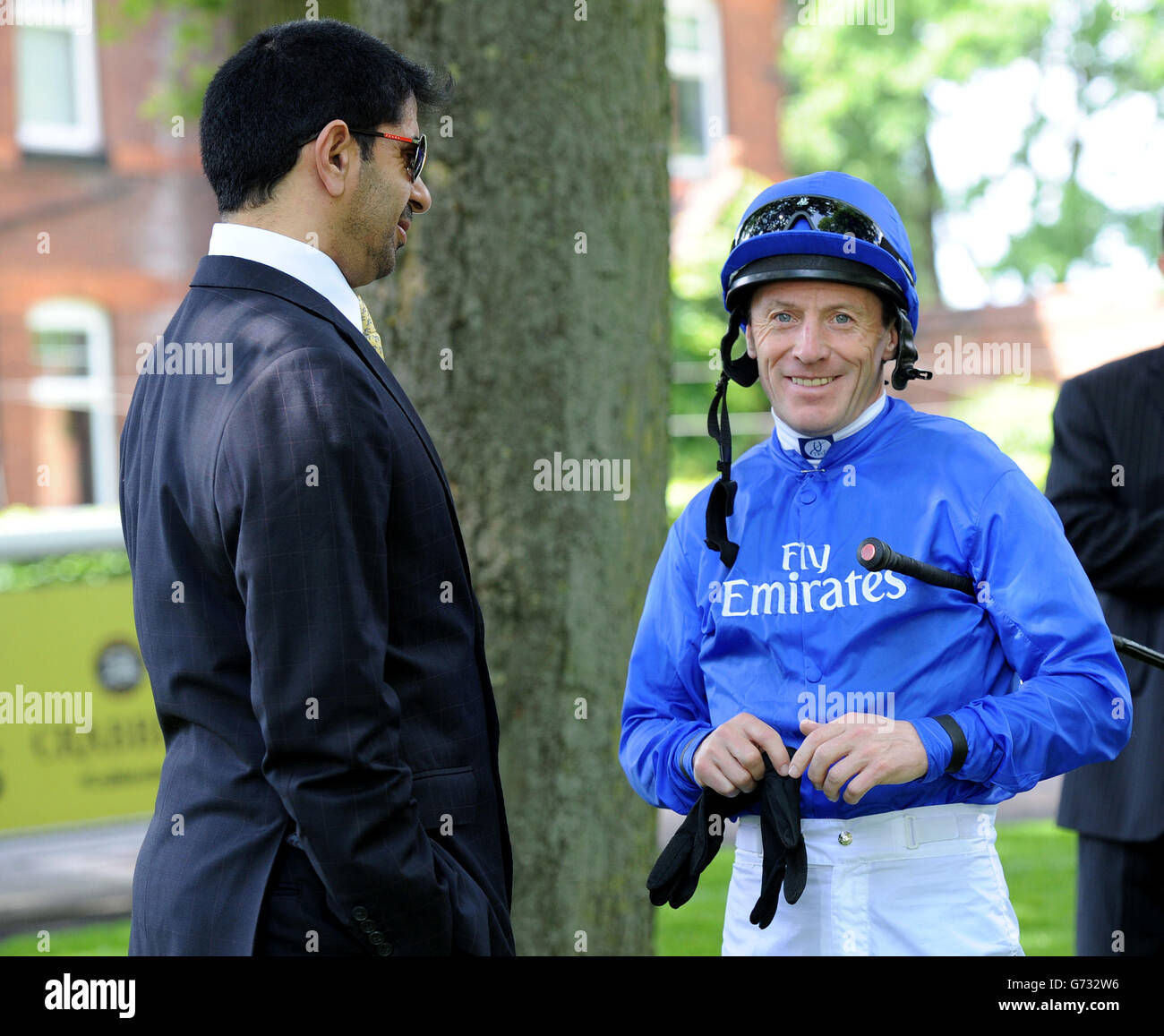 Jockey Kieren Fallon wears the Godolphin blue silks as he talks to trainer Saeed bin Suroor during the Sandy Lane Stakes day at Haydock Park Racecourse. Stock Photo