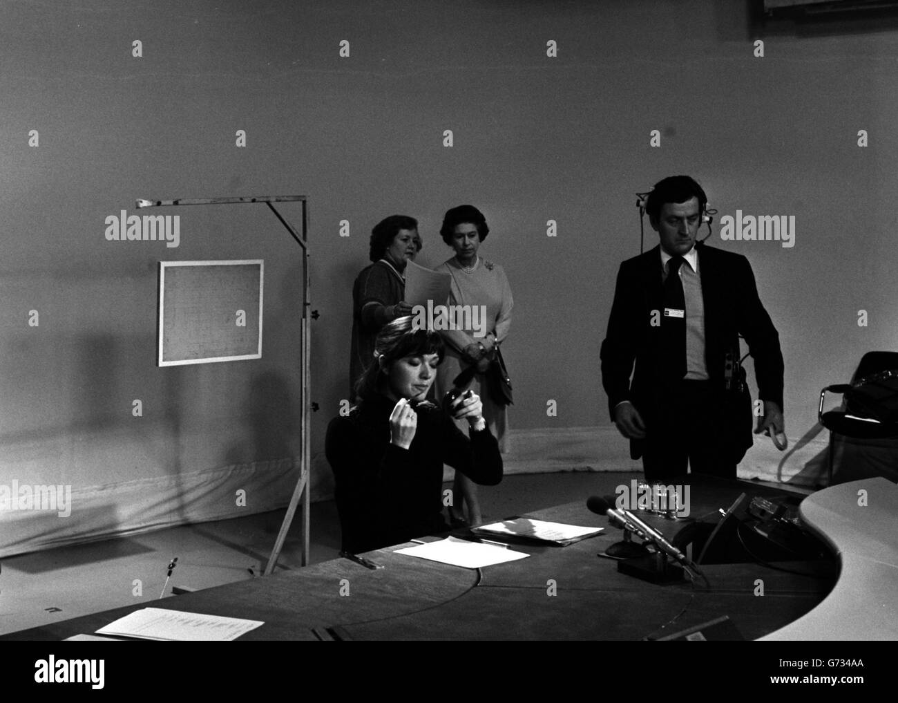 Independent TV Newsreader, Anna Ford making last minute changes to her make up in the studios of the News at Ten, at ITN House, Wells Street, London, watched by Queen Elizabeth II and Diana Edwards-Jones, a programme editor (holding paper). The Queen, accompanied by the Duke of Edinburgh, was visiting ITN to mark its Silver Jubilee. Stock Photo
