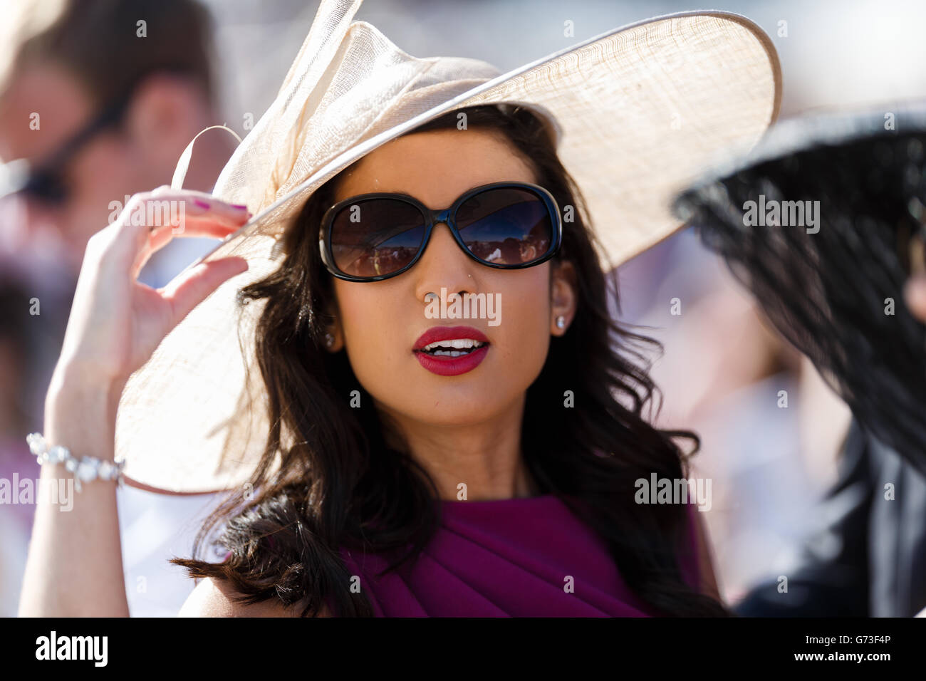 Horse Racing - Investec Ladies Day 2014 - Epsom Downs Racecourse. A racegoer enjoys her day at the races Stock Photo