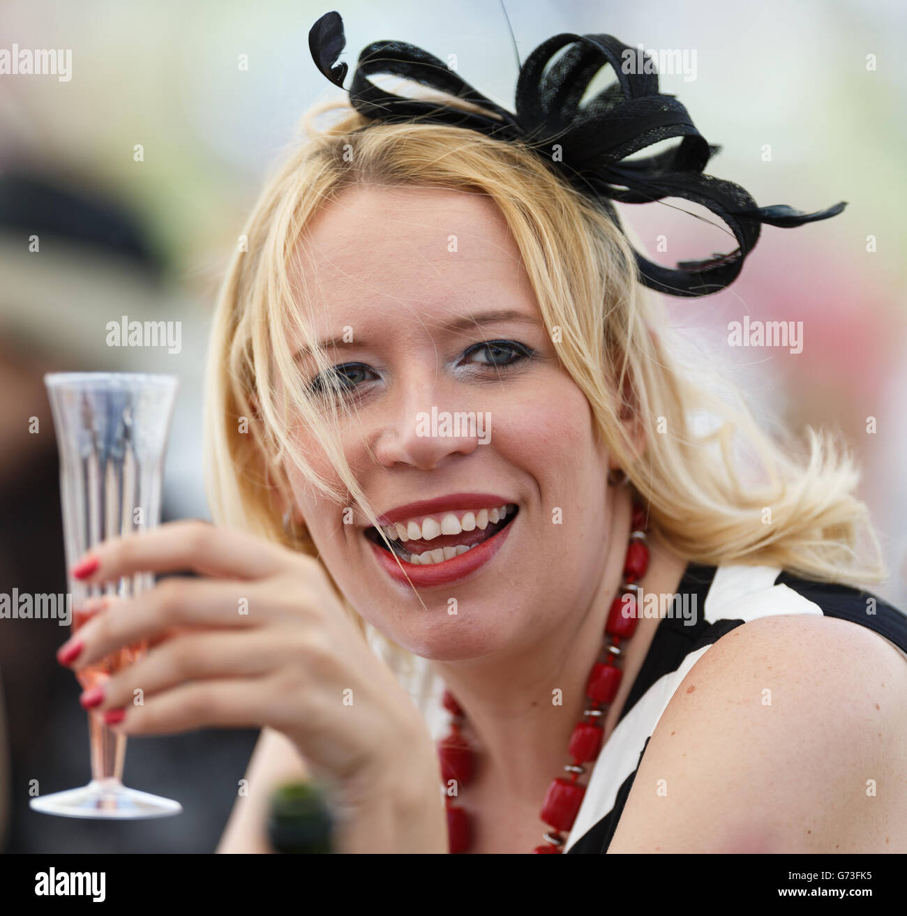 Horse Racing - Investec Ladies Day 2014 - Epsom Downs Racecourse. A racegoer enjoys her day at the races Stock Photo