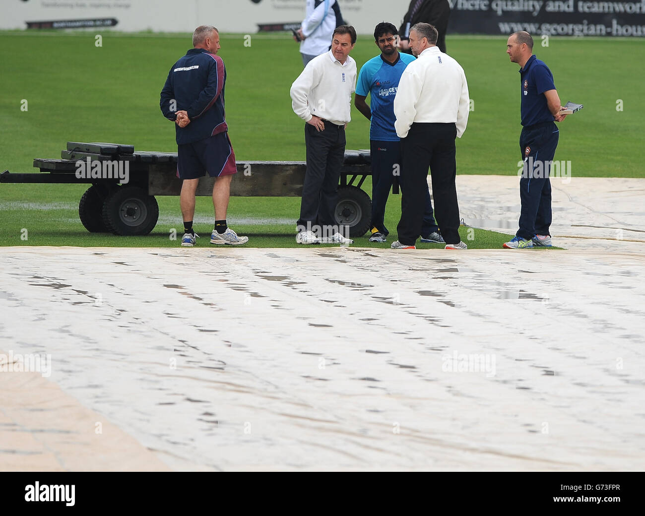 Umpires Paul Pollard (2nd right) Steve O'Shaunghnessy (2nd left), Sri Lanca's Captain Lahiru Thirimanne (centre facing, Northants Captain, Stephen Peters and the groundsman (left) discuss the state of the pitch prior to abandoning play between Northamptonshire and Sri Lanka for the day. Stock Photo