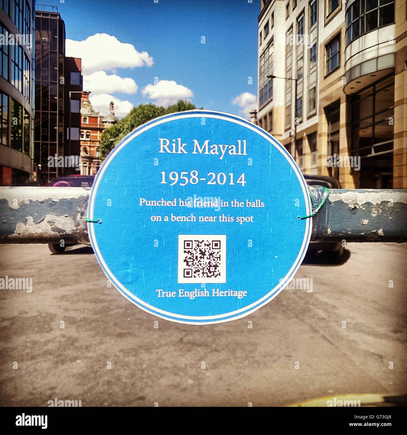 A temporary English Heritage style blue plaque in Hammersmith, west London, dedicated to the comic actor Rik Mayall who died yesteday, the QR code on the plaque links to a Youtube clip showing the opening scene of the comedy series 'Bottom' that was filmed in Hammersmith. Stock Photo