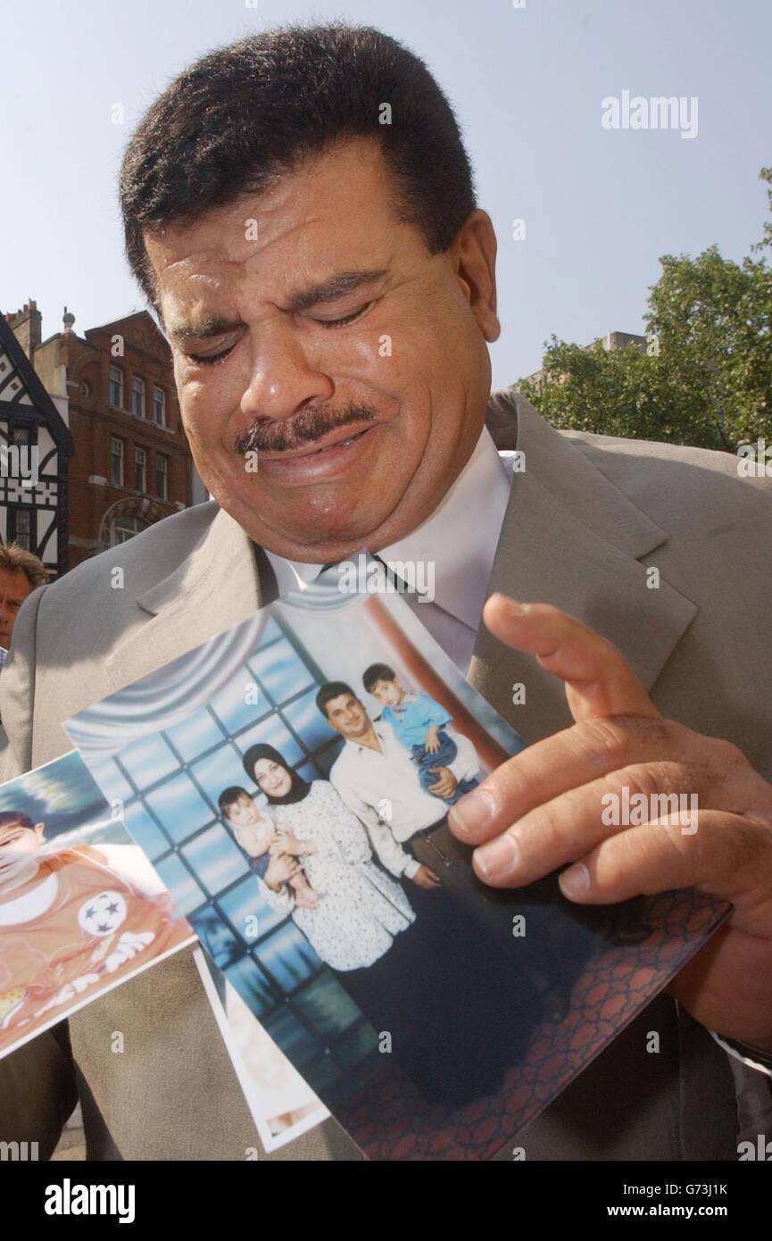 Daoud Mousa holds pictures of his grandchildren and son Baha outside