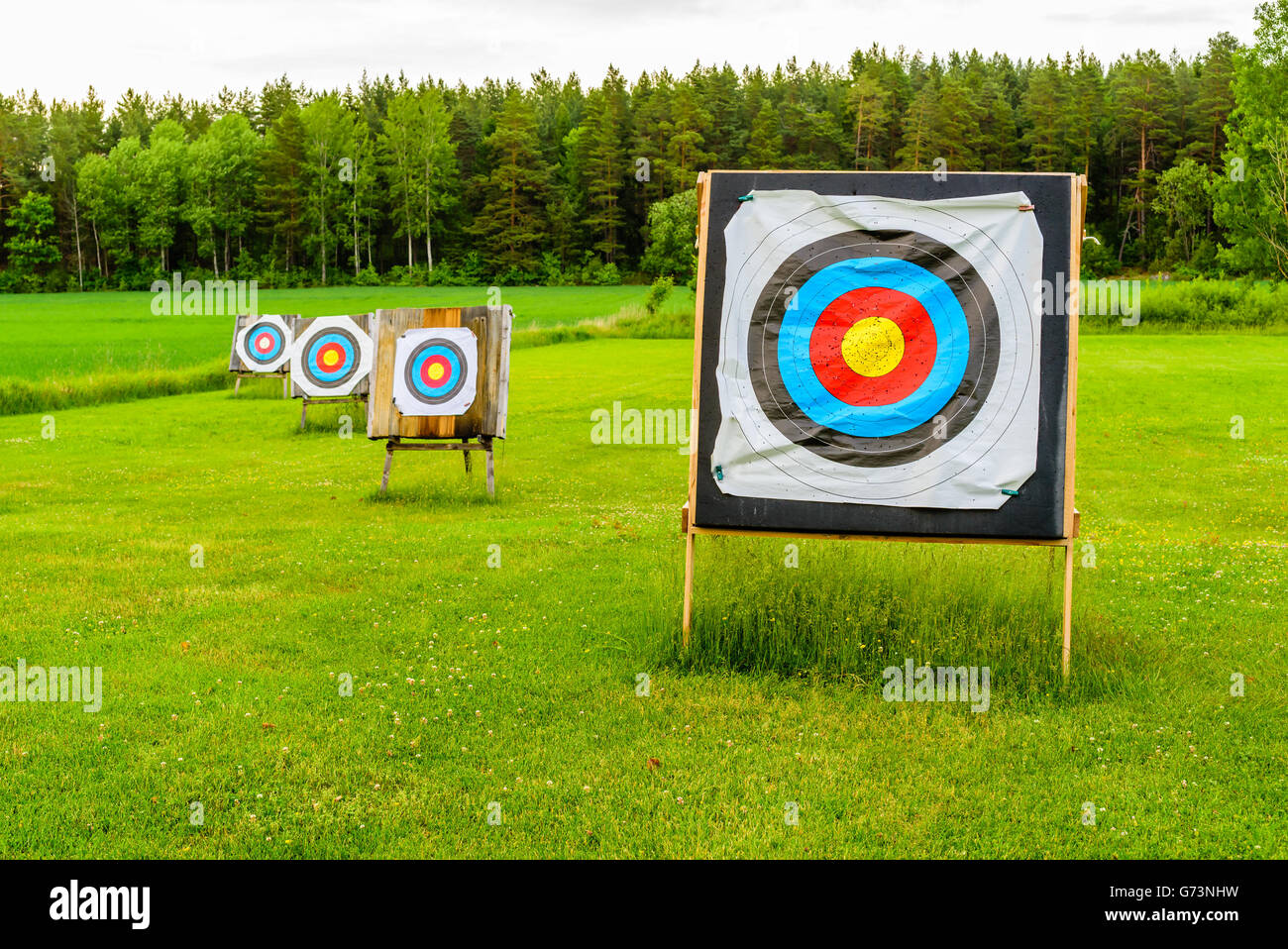Outdoor archery targets on grass field surrounded by forest in the summer  evening Stock Photo - Alamy