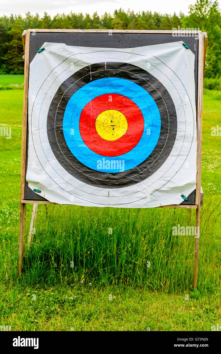 Outdoor archery targets on grass field surrounded by forest in the