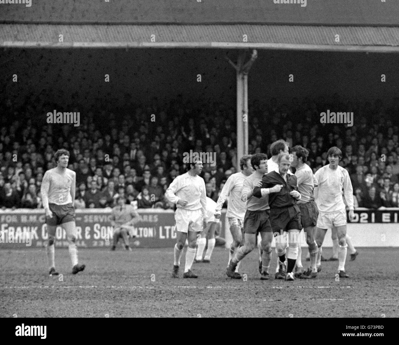 Referee Ray Tinkler is protected by West Bromwich Albion players, in dark shorts, and surrounded by Leeds United players when angry Leeds supporters attacked him after Geoff Astle socred a hotly disputed goal in the game West Bromwich Albion won 2-1 at Elland Road. Stock Photo