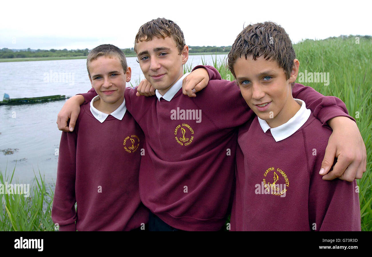 Three quick-thinking teenage boys who saved an elderly man stranded in mud for more than eight hours were praised for their actions. Left to right, Sam Shinar, Noel Creech and Mathew Pepper, all 13, from Hamworthy in Poole, Dorset, back at the scene in Dorset. The boys were playing on a small boat moored in Lytchett Bay on Wednesday 14 July when they spotted the pensioner in trouble just before 6.30pm. Stock Photo