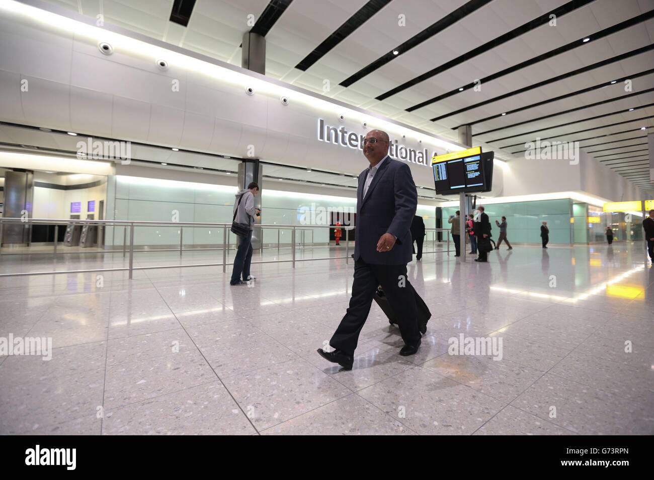 One of the first passengers to arrive at Heathrow's Terminal 2, the Queen's Terminal, Mohan Rao walks through the terminal building. Stock Photo