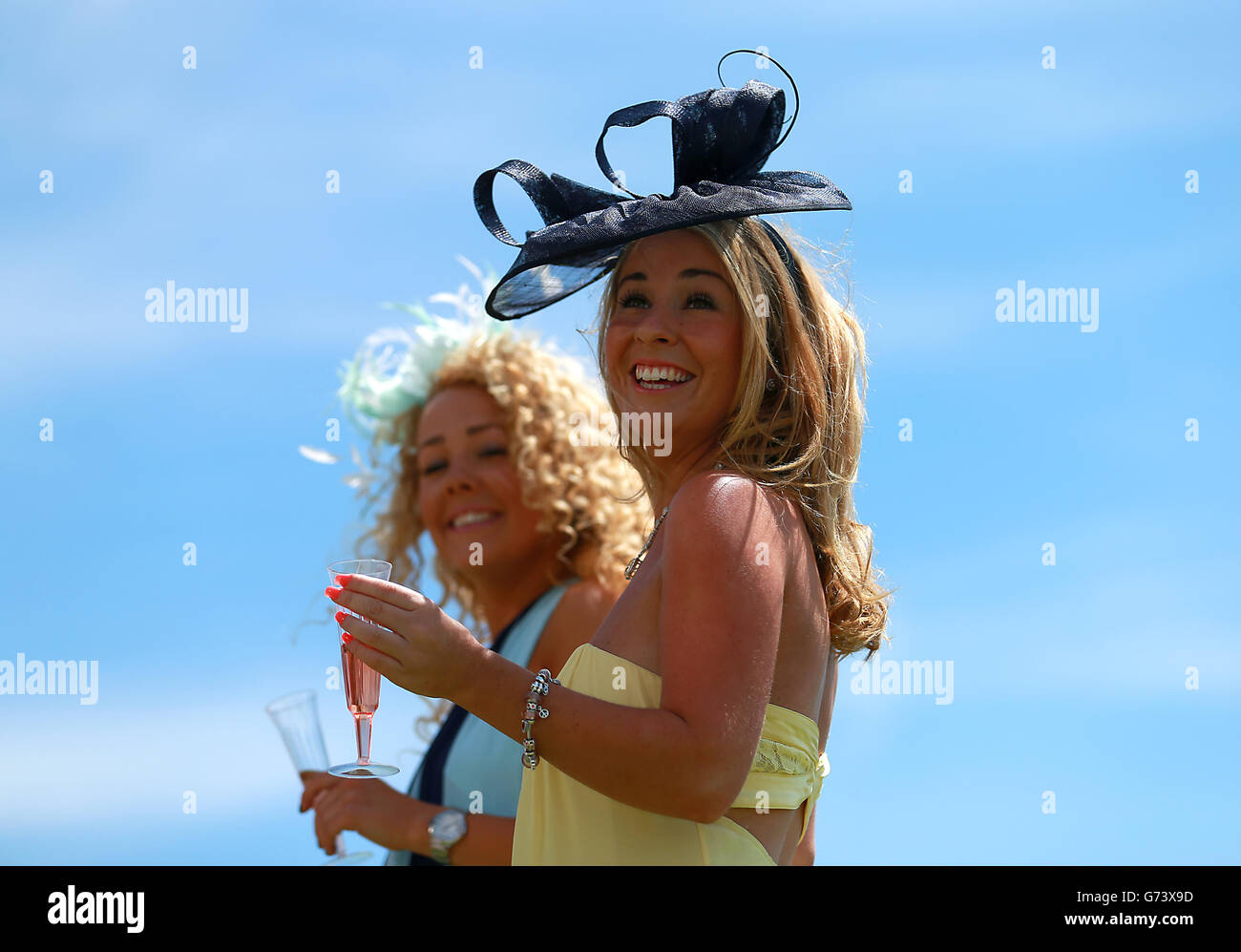 A race goer enjoys the racing during Investec Ladies Day at Epsom Downs Racecourse, Surrey. Stock Photo
