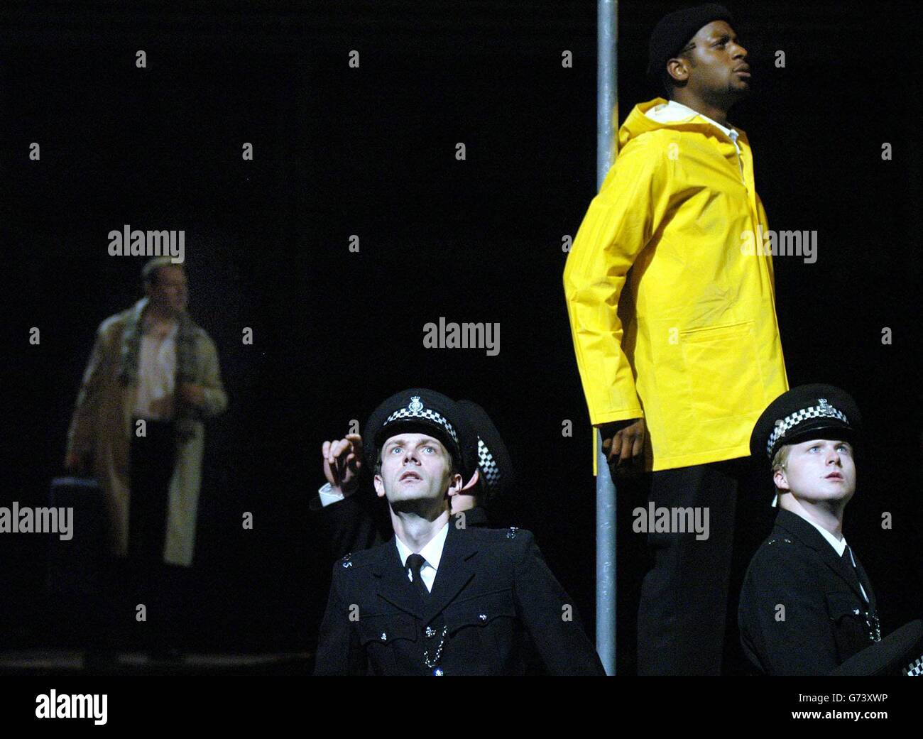 Iain Paterson playing the role of the 'Traveller' (far left), Rodney Clarke, the role of the 'Ferry Man' (second right) in the yellow anorak and members of the Police Chorus, singers from the Birmingham Opera Company, practice during a dress rehearsal of the opera, 'Curlew River' by Benjamin Britten at the Royal Albert Hall in Londo, which tonight will play as Prom 17, as part of the BBC Proms.The opera is directed by Graham Vick and features singers from the Birmingham Opera Company, it is the first time that an opera has been shown at the Proms. Stock Photo