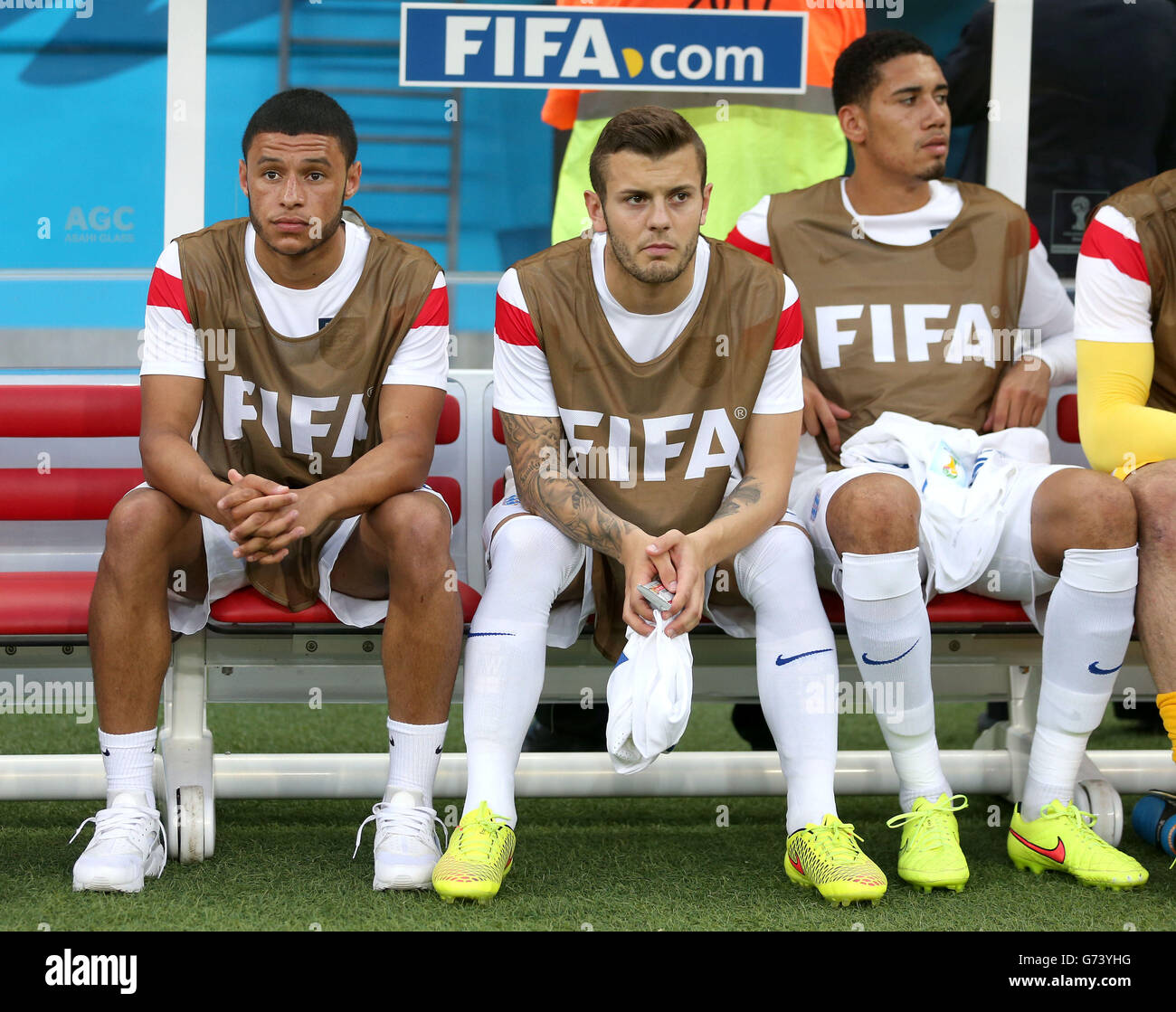 England's Jack Wilshere (centre), England's Alex Oxlade-Chamberlain (left) and England's Chris Smalling in the dugout during the FIFA World Cup, Group D match at the Arena da Amazonia, Manaus, Brazil. Stock Photo