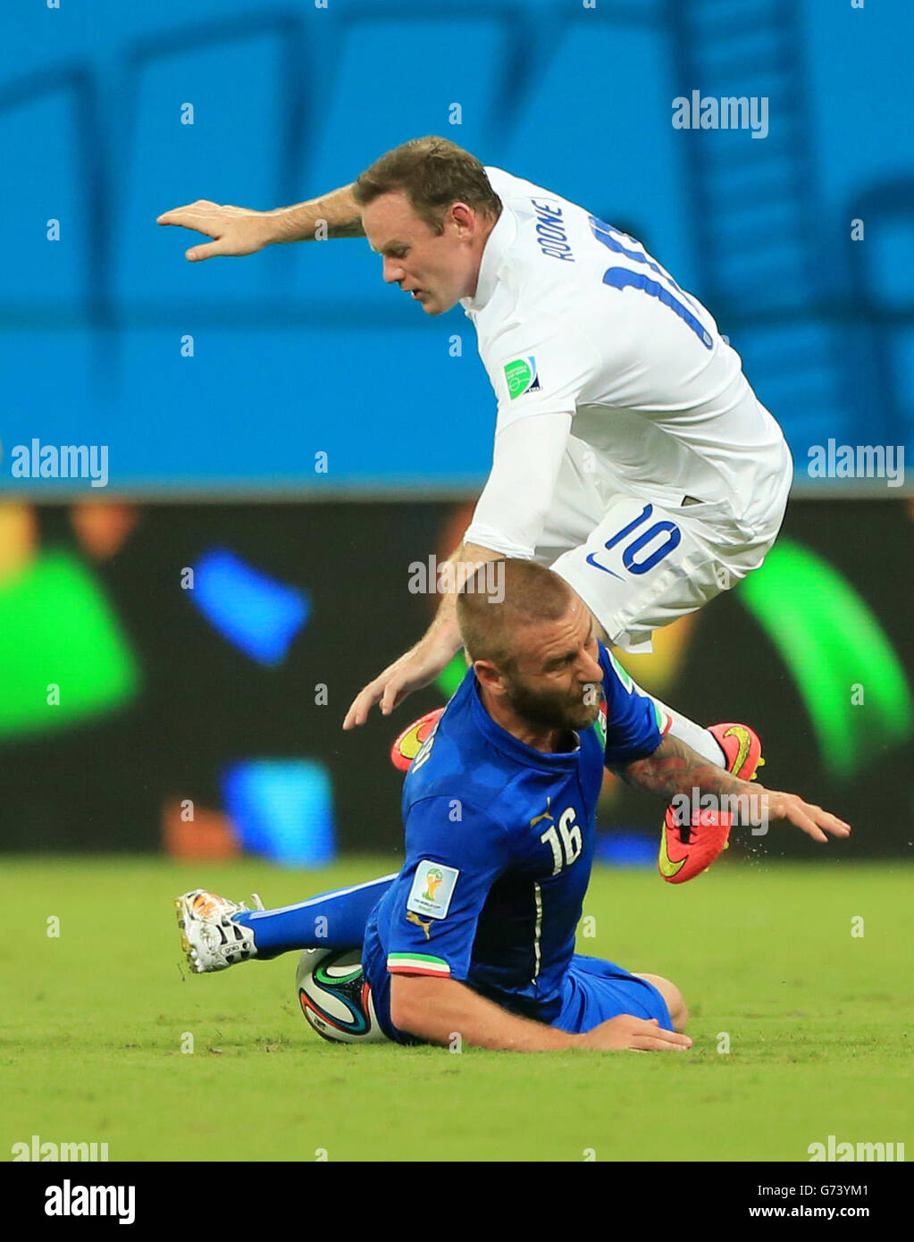 England's Wayne Rooney is tackled by Italy's Daniele de Rossi (bottom) during the FIFA World Cup, Group D match at the Arena da Amazonia, Manaus, Brazil. Stock Photo
