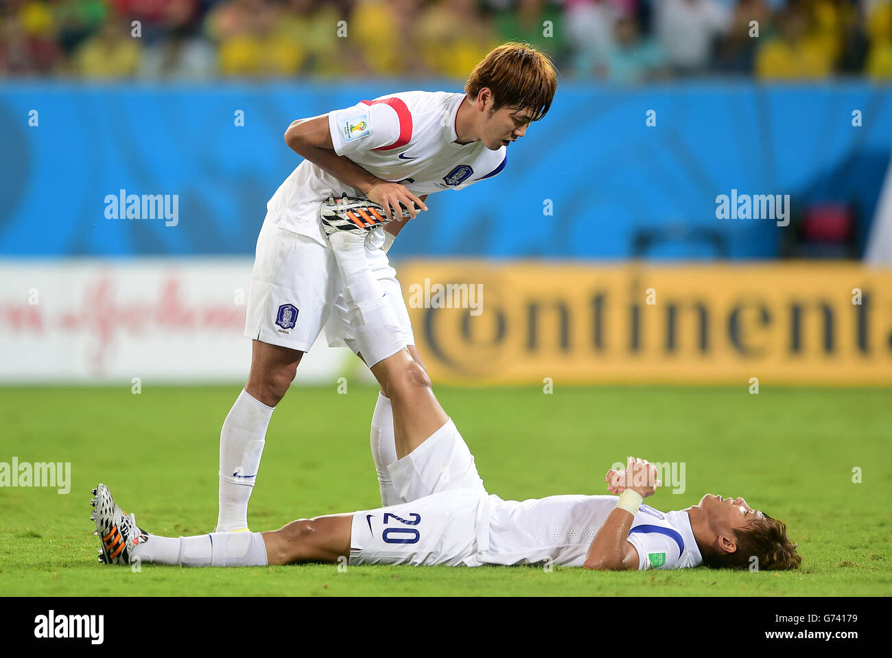 Soccer - FIFA World Cup 2014 - Group H - Russia v South Korea - Arena Pantanal. South Korea's Hong Jeong-Ho receives treatment for cramp from team-mate Kim Young-Gwon Stock Photo