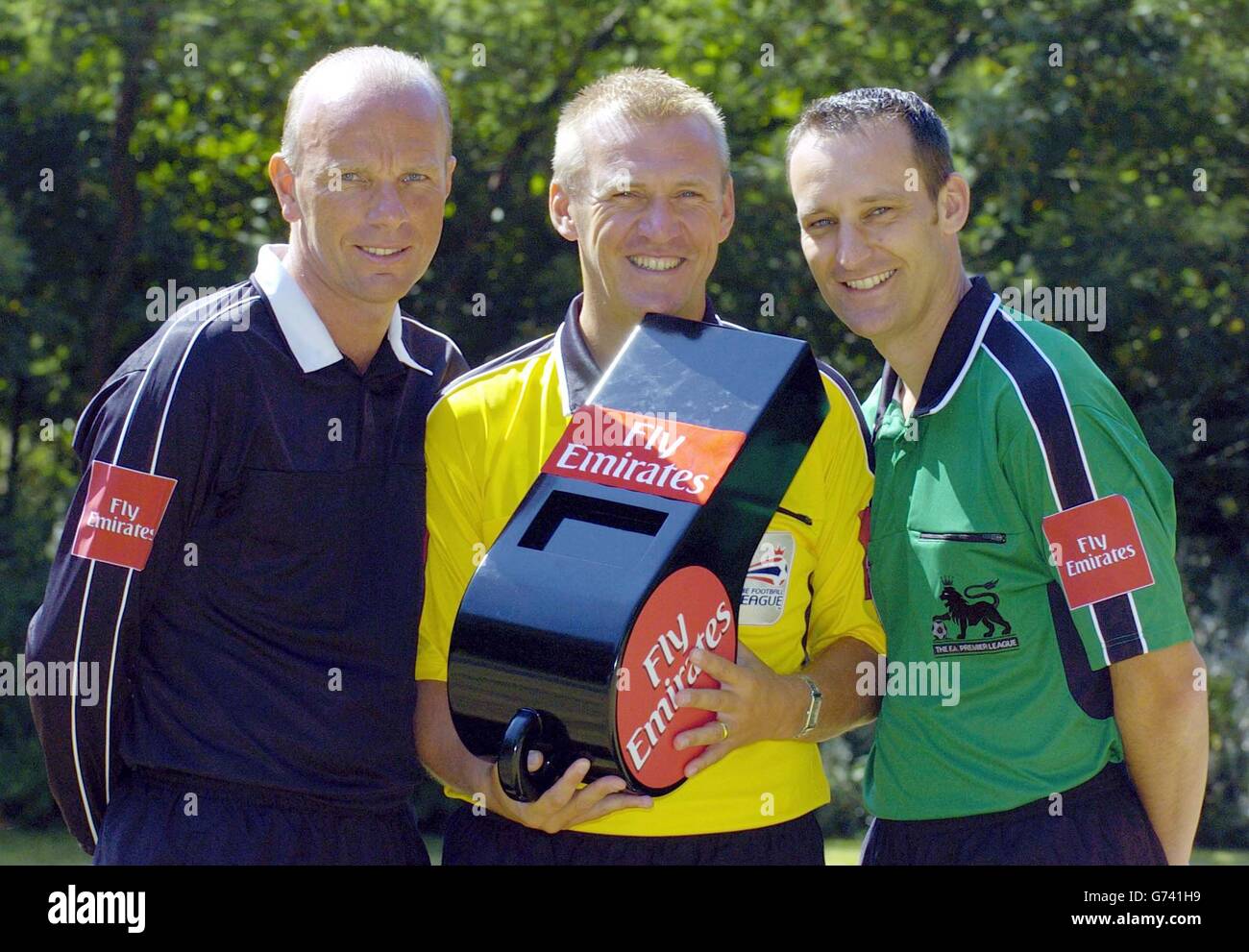 Referees (l-r) Steve Bennett, Graham Poll and Matt Messias model the Fly Emirates logo on the sleeve of his shirt, outside the Carlton House Hotel in central London. Referees and match officials in English football are set to be sponsored by the airline as from Saturday August 14, 2004, when the Barclays Premiership season kicks off. Stock Photo