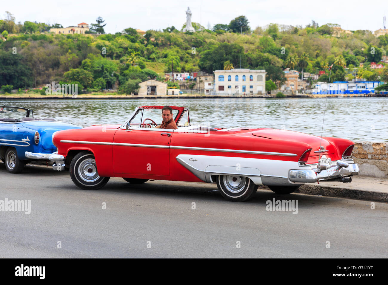 1950s American Lincoln Capri convertible classic car in red, being parked by the driver on the seafront in Havana, Cuba Stock Photo
