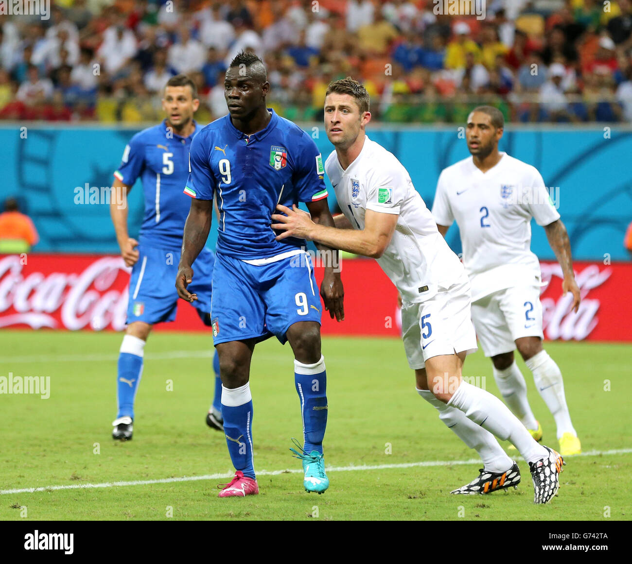 Italy's Mario Balotelli (left) and Gary Cahill tussle in the box during the FIFA World Cup, Group D match at the Arena da Amazonia, Manaus, Brazil. Stock Photo