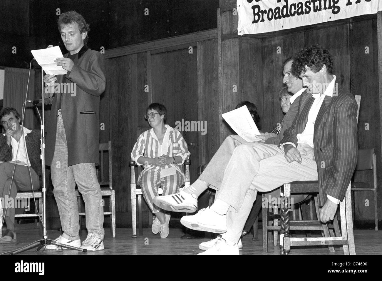 TV comedian Rik Mayall reads an extract from the banned Peter Wright book Spycatcher, at an event organised by the Campaign for Press and Broadcasting Freedom at Conway Hall in London. Former Monty Python member Michael Palin is seated on the right. Stock Photo