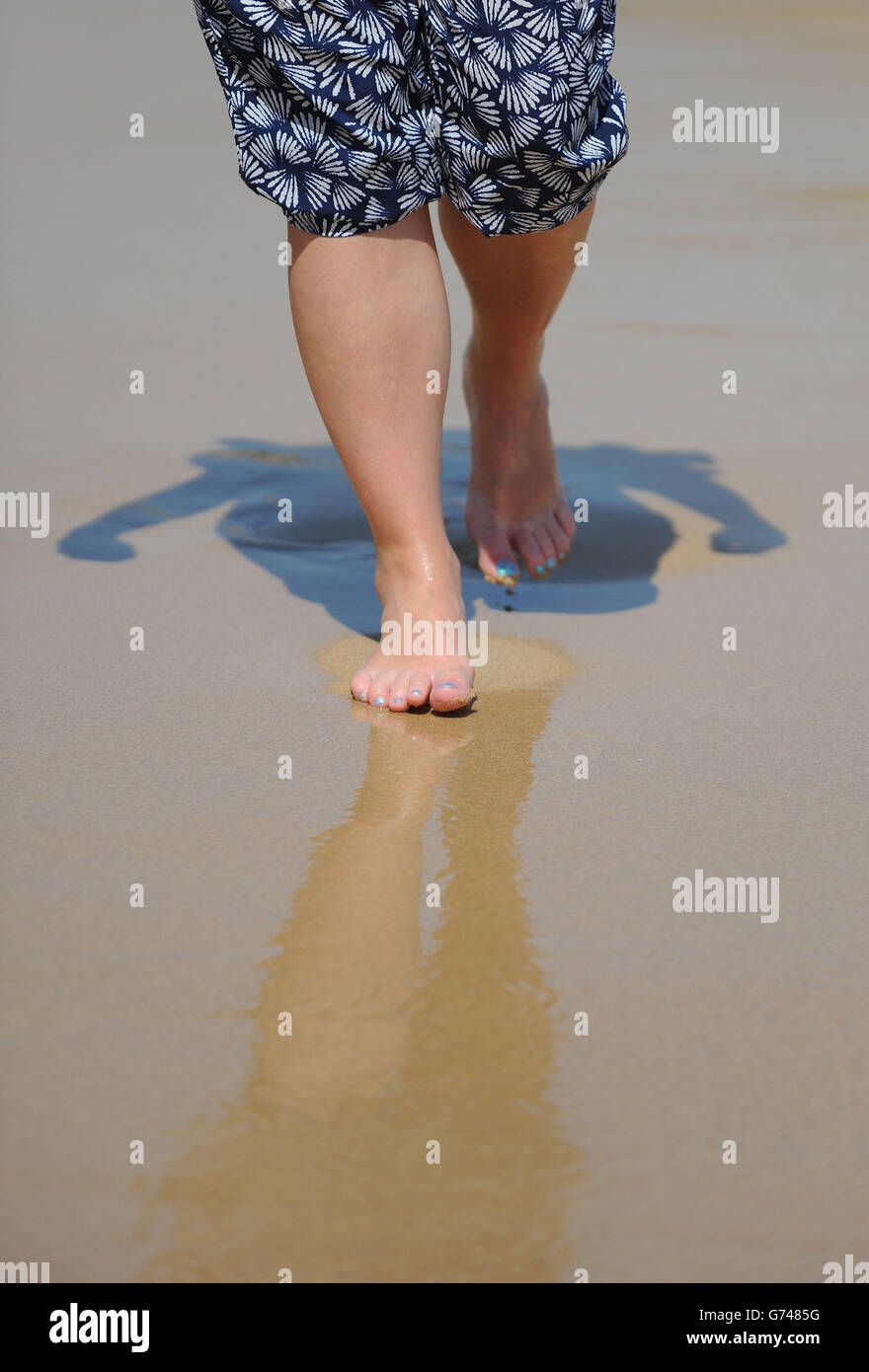 Generic stock photo of feet in flip flops on the beach at Praia da Luz