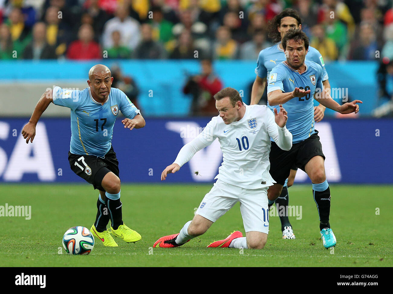 England's Wayne Rooney (centre) in action with Uruguay's Alvaro Gonzalez (right) and Uruguay's Egidio Arevalo Rios (left) during the Group D match the Estadio do Sao Paulo, Sao Paulo, Brazil. Stock Photo