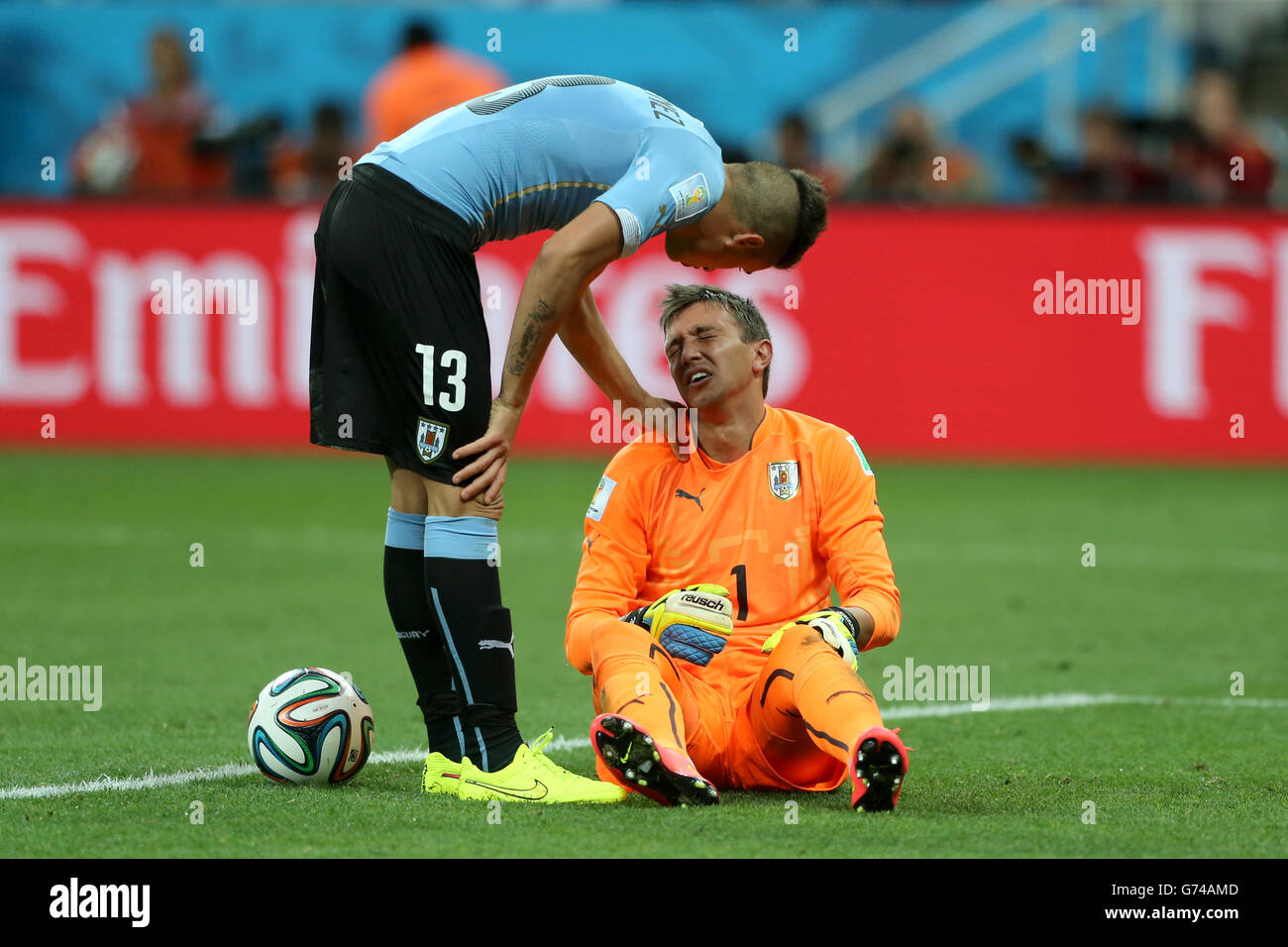 Uruguay goalkeeper Fernando Muslera (right) reacts after a coming together with England's Danny Welbeck during the Group D match the Estadio do Sao Paulo, Sao Paulo, Brazil. Stock Photo