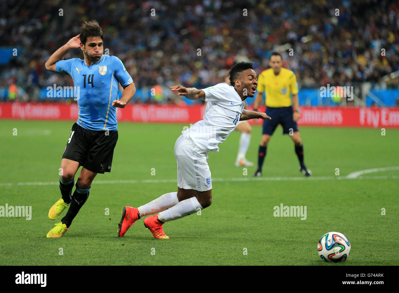 Soccer - FIFA World Cup 2014 - Group D - Uruguay v England - Estadio Do Sao Paulo. England's Raheem Sterling (right) goes down in the box under a challenge from Uruguay's Nicolas Lodeiro Stock Photo