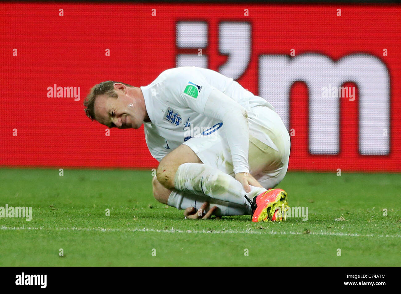 England's Wayne Rooney goes down clutching his ankle during the Group D match the Estadio do Sao Paulo, Sao Paulo, Brazil. Stock Photo