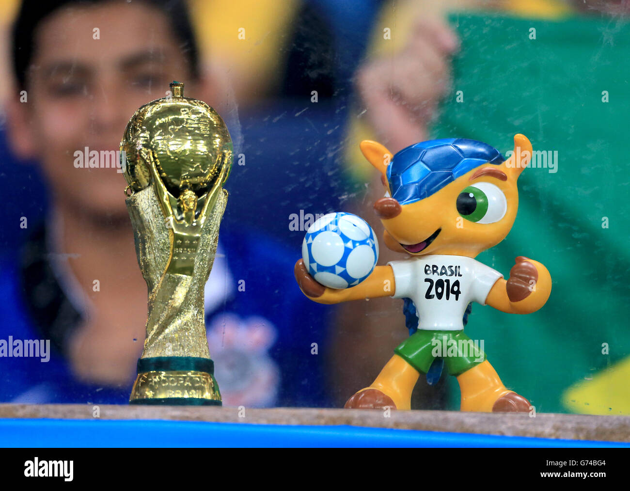 A FIFA World Cup trophy replica alongside a model of Fuleco the 2014 FIFA World Cup Mascot Stock Photo