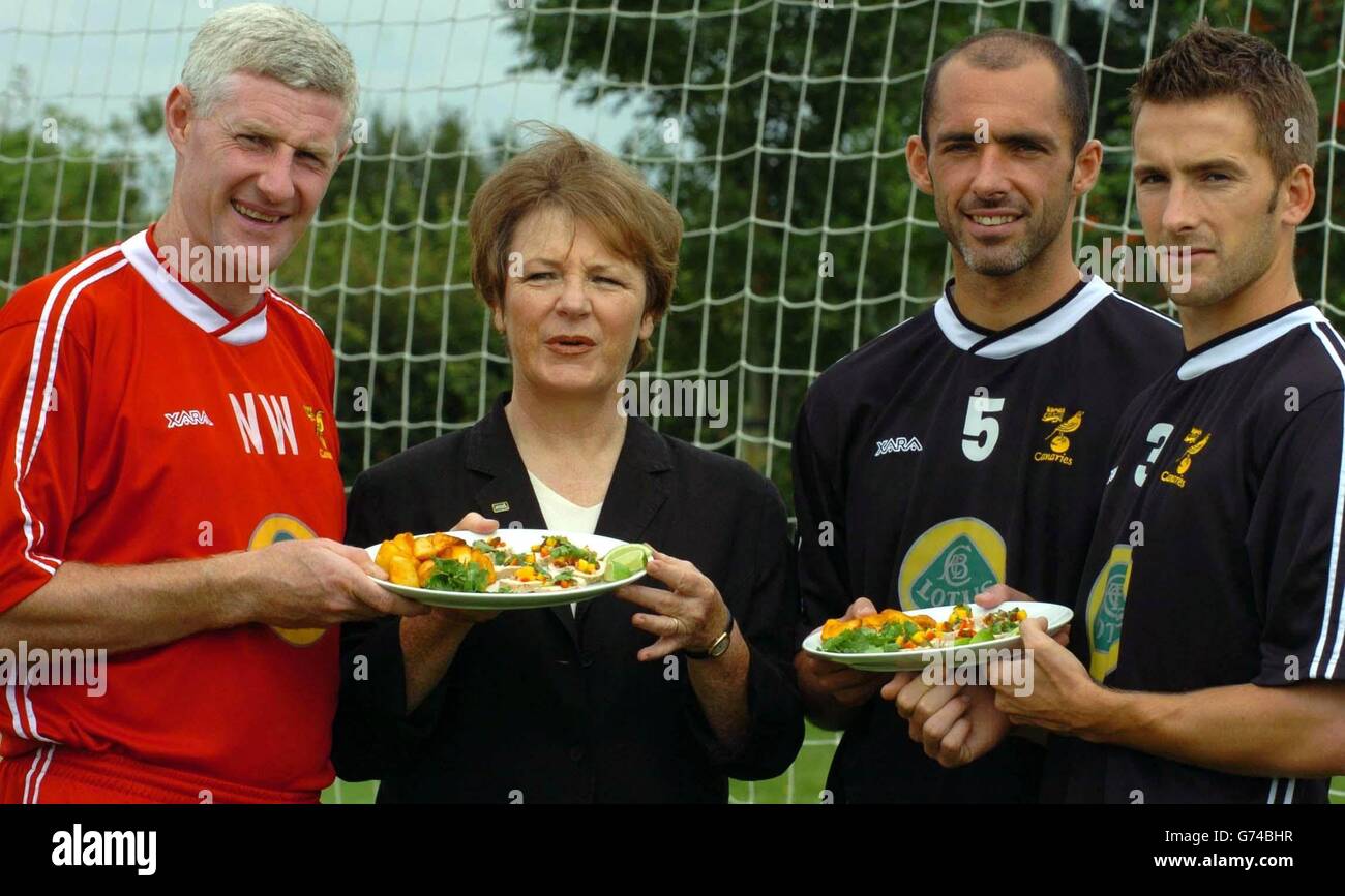 Norwich City Football Club Director Delia Smith is sandwiched between Norwich City players Adam Drury (right, Captain) and Craig Fleming (left, Club Captain)and manager Nigel Worthington (l) at the Norwich City training ground in Norwich. The celebrity chef and club shareholder shows off a plate of food that forms part of her Fuel Time Plan, a carbohydrate-rich, low-fat eating strategy for the team. Stock Photo