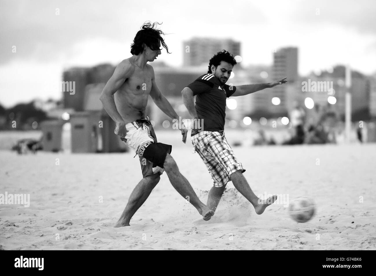 Brazilian youth play football at dusk on the Copacabana Beach in Rio de Janeiro Stock Photo