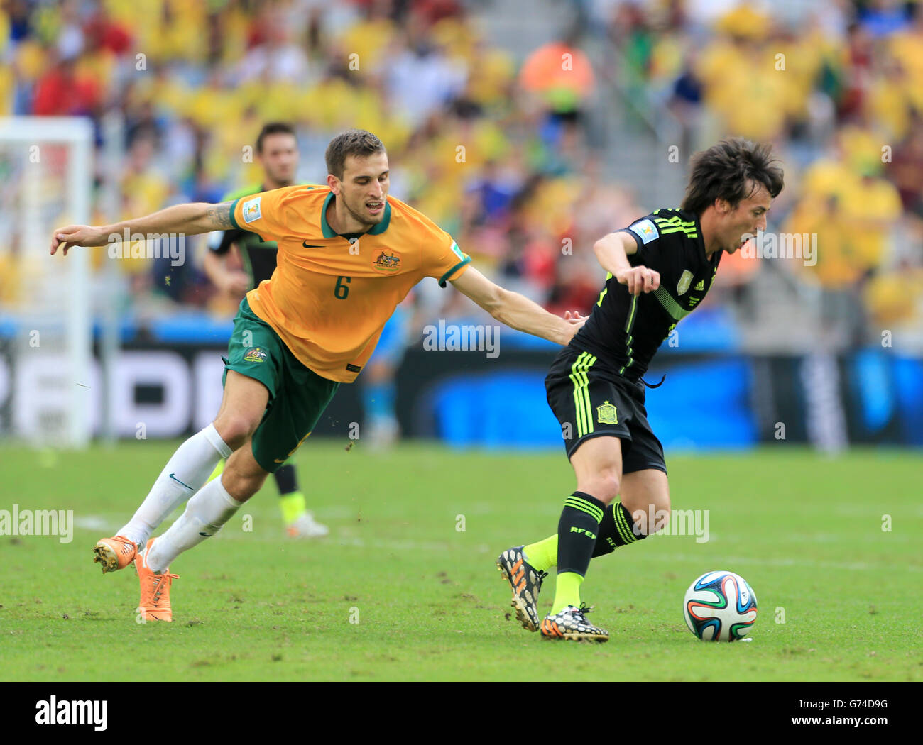 Soccer - FIFA World Cup 2014 - Group B - Australia v Spain - Arena da Baixada. Australia's Matthew Spiranovic battles for the ball with Spain's David Silva Stock Photo