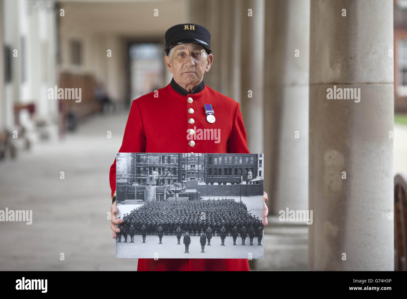 (Left to right) Chelsea Pensioner Lawrence Jablonski holds a picture of the Post Office Rifles on parade, at an exhibition honouring the Post Office Rifles, which is on display at the Chelsea Hospital in London. Stock Photo
