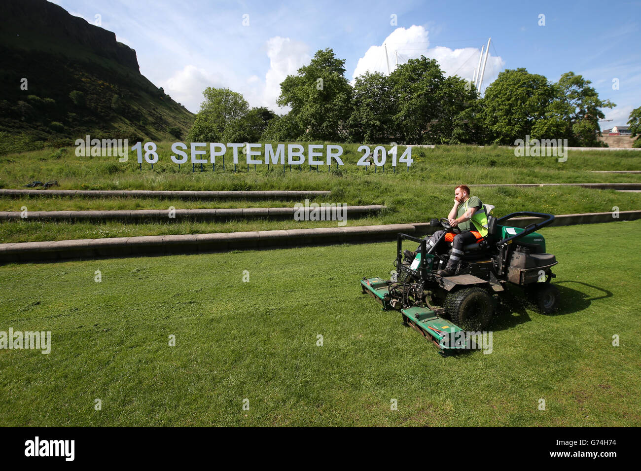 A grass cutter passes an '18 September 2014' sign outside the Scottish Parliament as there are 100 days to go until the referendum. Stock Photo