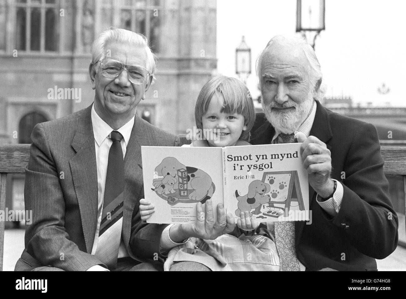 Gwenan Lockley of Llanrindod, Wales, reads the Welsh edition of a Spot children's book to Jack Ashley MP (left) and Spot creator Eric Hill. She was one of a group of children who demonstrated their reading abilities to mark the publishing of the books in minority languages, as well as marking Spot's BBC TV debut on April 9th. Stock Photo