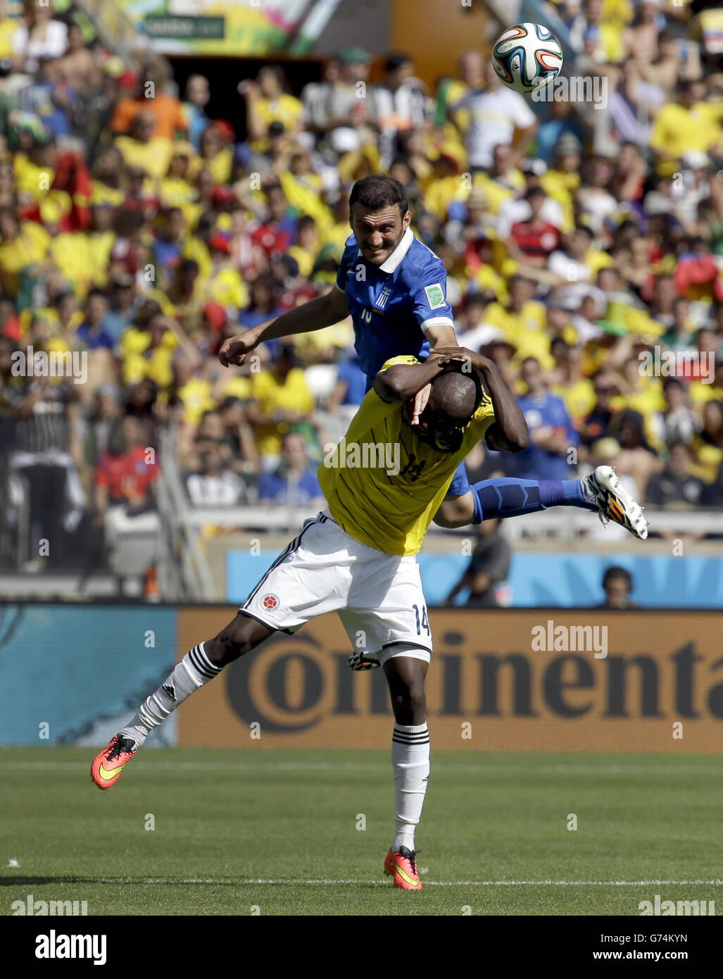 Greece's Vasilis Torosidis, top, heads the ball over Colombia's Victor Ibarbo during the group C World Cup soccer match between Colombia and Greece at the Mineirao Stadium in Belo Horizonte, Brazil, Saturday, June 14, 2014. (AP Photo/Fernando Vergara) Stock Photo