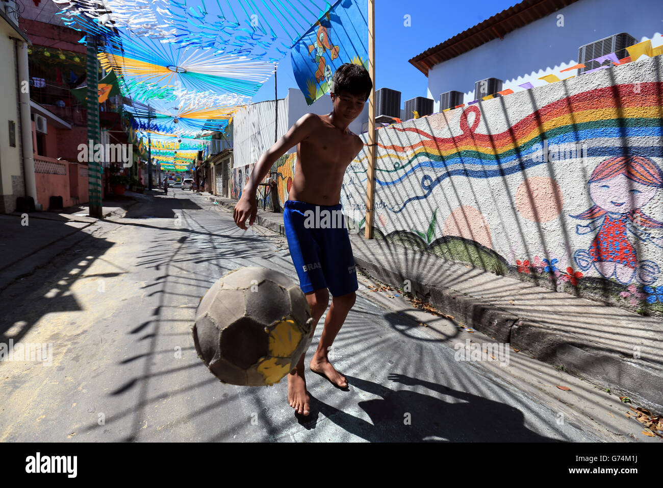 Soccer - FIFA World Cup 2014 - Group D - England v Italy - Arena da Amazonia. A local boy plays football in the street ahead of this evenings match at the Arena da Amazonia, Manaus, Brazil. Stock Photo