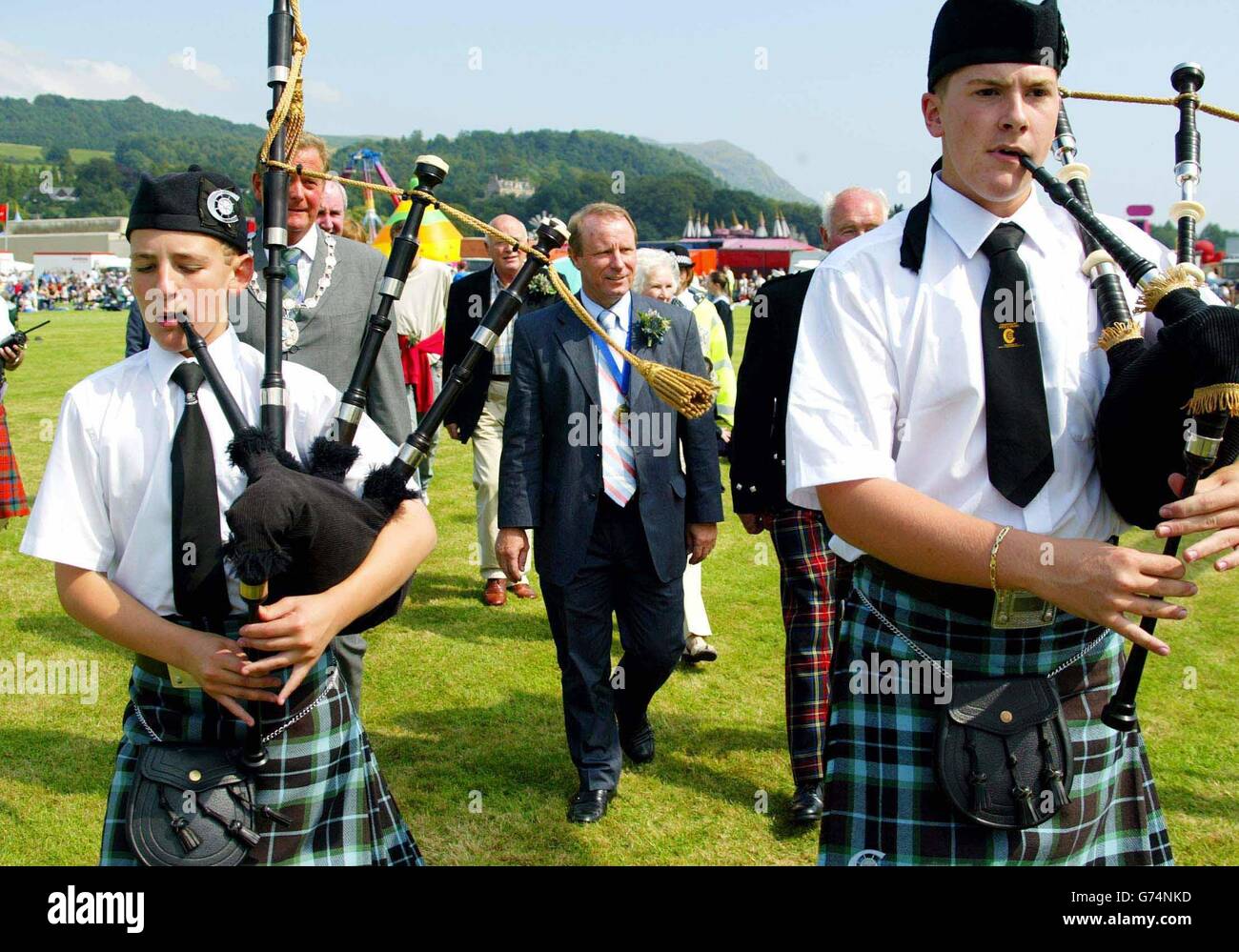 Scotland football manager Berti Vogts walks behind bagpipers at Bridge of Allan Highland Games near Stirling, where he is head Chieftan at this years games. Stock Photo