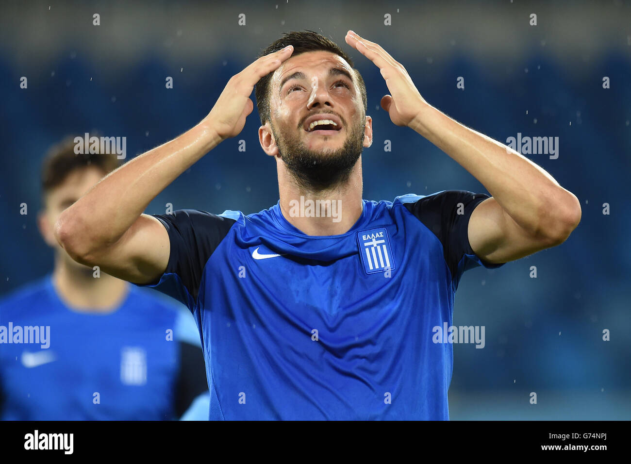 Soccer - FIFA World Cup 2014 - Group C - Japan v Greece - Greece Training and Press Conference - Estadio das Dunas. Greece's Andreas Samaris reacts as rain begins to fall during a training session at Arena das Dunas in Natal Stock Photo
