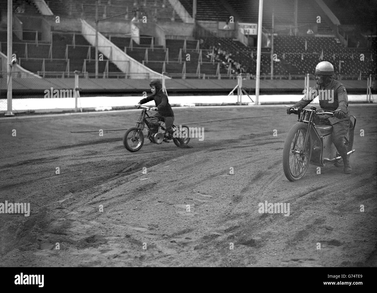 Walter Brierley, 7, races Yorkshire track racer Eva Asquith at Wembley Stadium. The 1.5 horsepower bike was made for him by his father, also called Walter Brierley, a motor engineer from Wembley. Stock Photo
