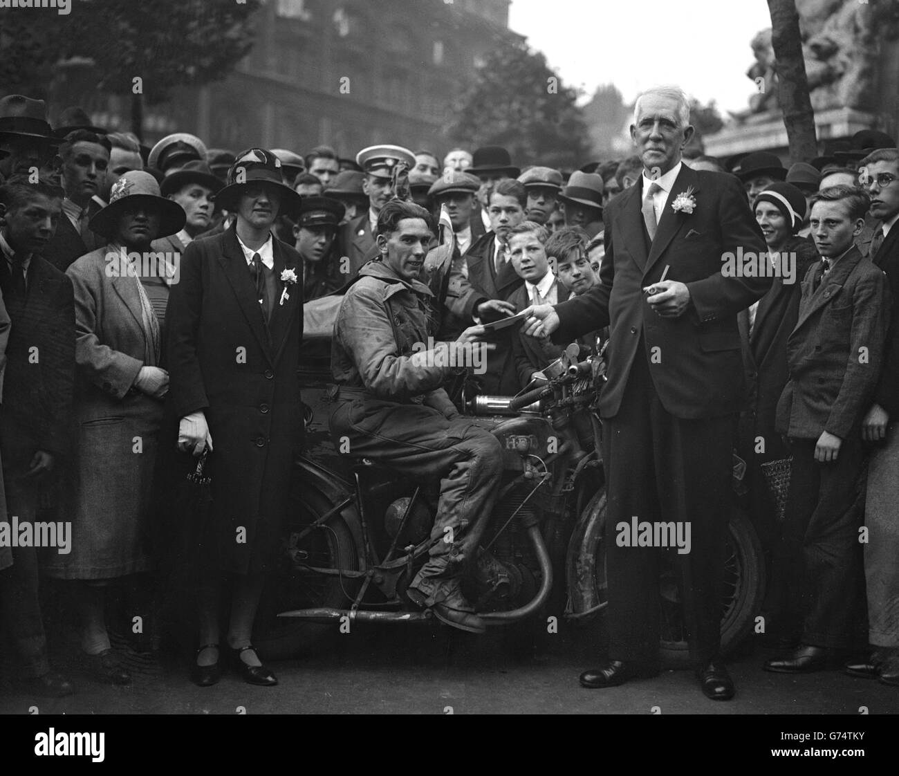 London motorcyclist John Gill arrives at Australia House to deliver a letter to F Trumble from the Australian premier. Gill has ridden across Europe and Asia on his journey to Australia. Stock Photo