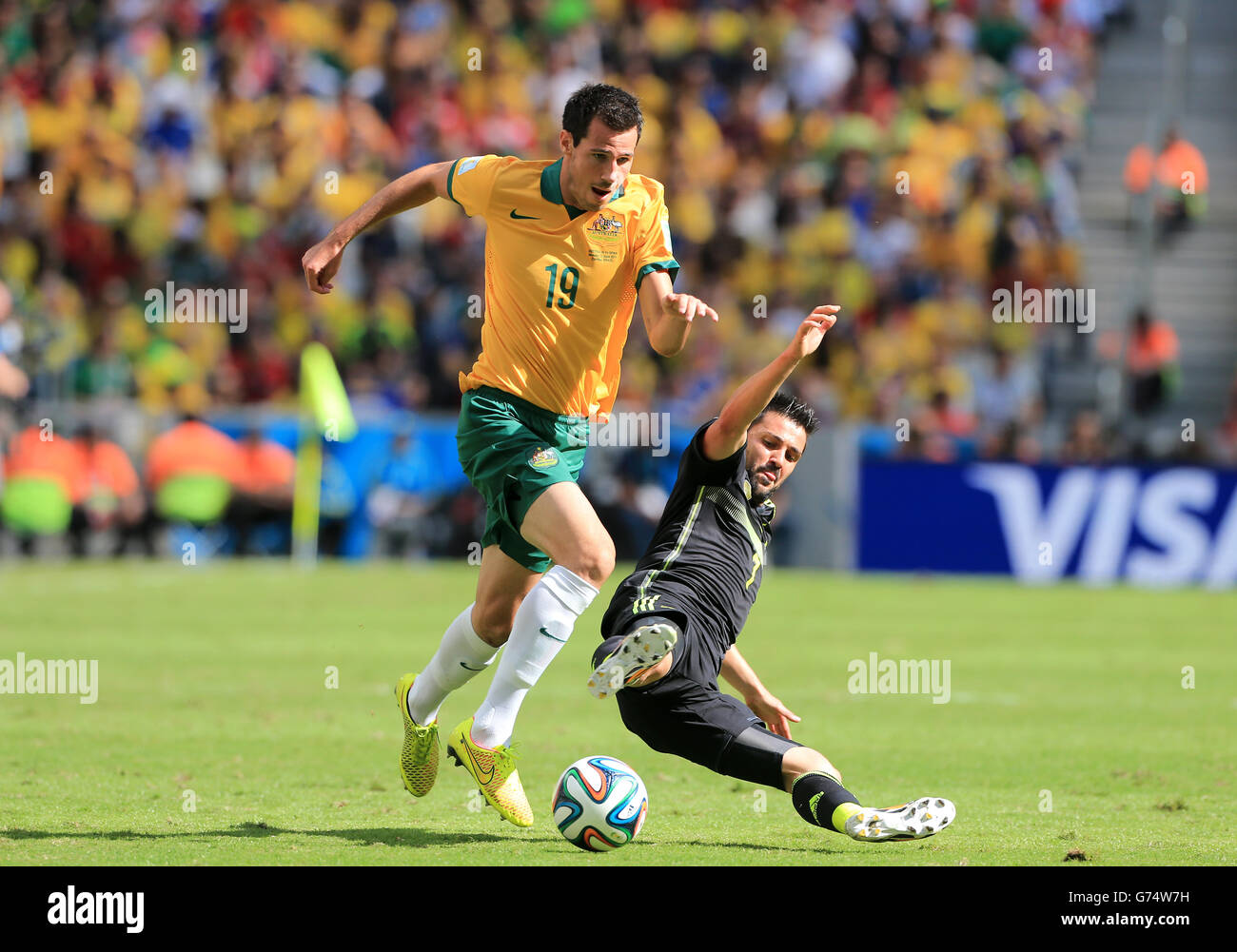 Soccer - FIFA World Cup 2014 - Group B - Australia v Spain - Arena da Baixada. Australia's Ryan McGowan battles for the ball with Spain's David Villa Stock Photo