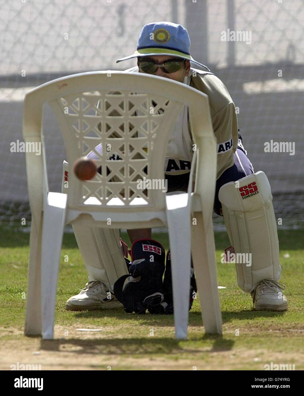 Indian wicketkeeper Deep Dasgupta using a garden chair as wickets
