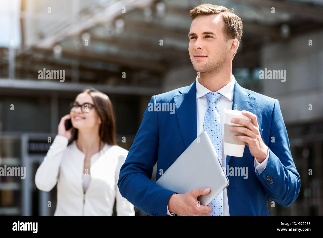 Handsome man standing near office building Stock Photo - Alamy