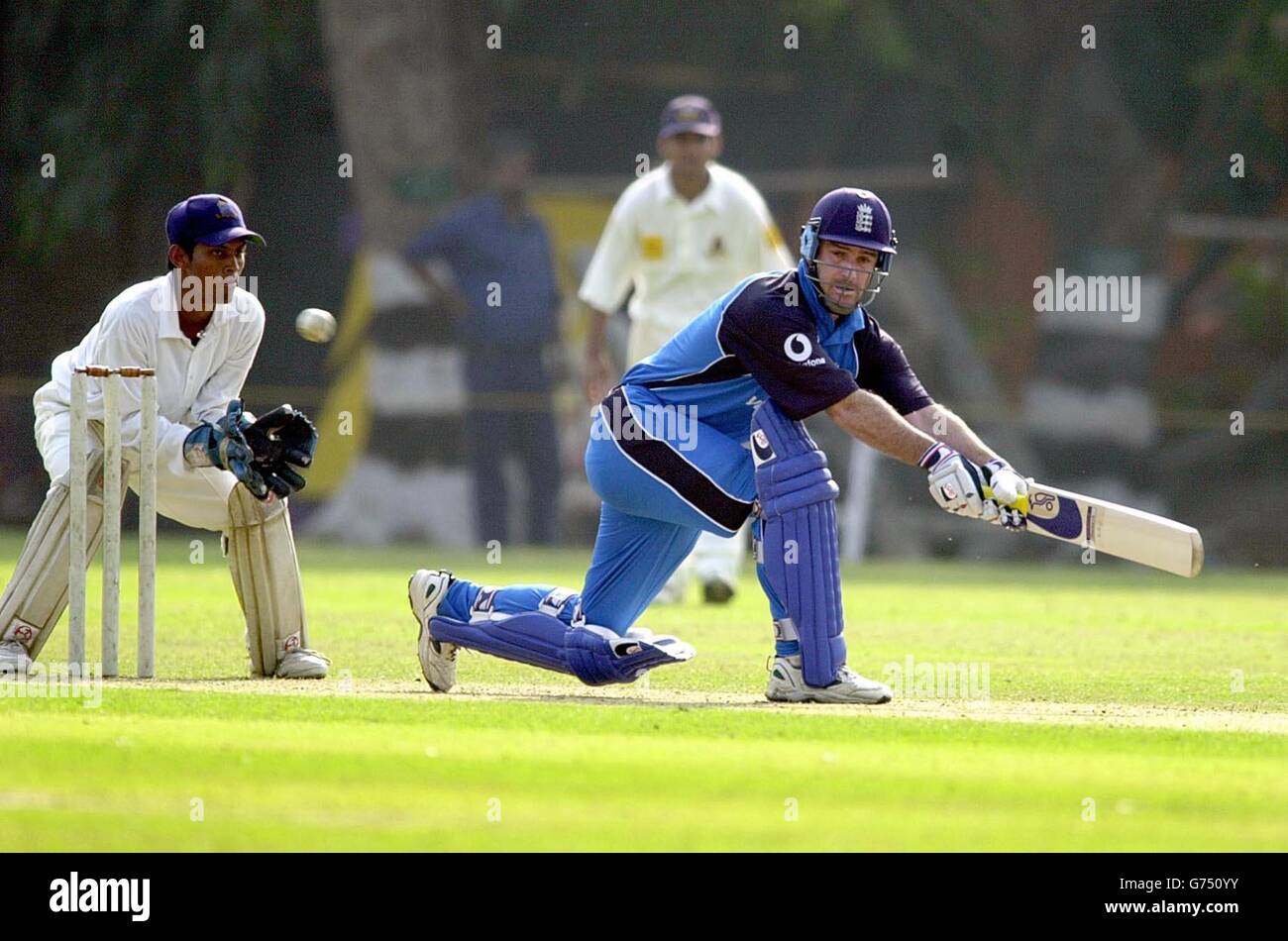England's Graham Thorpe sweeps the ball for 4 runs, watched by Bengal wicketkeeper Anirudha Roy, during the match against a Bengal Cricket Association XI at the Calcutta Cricket and Football Club, Calcutta, India. Stock Photo