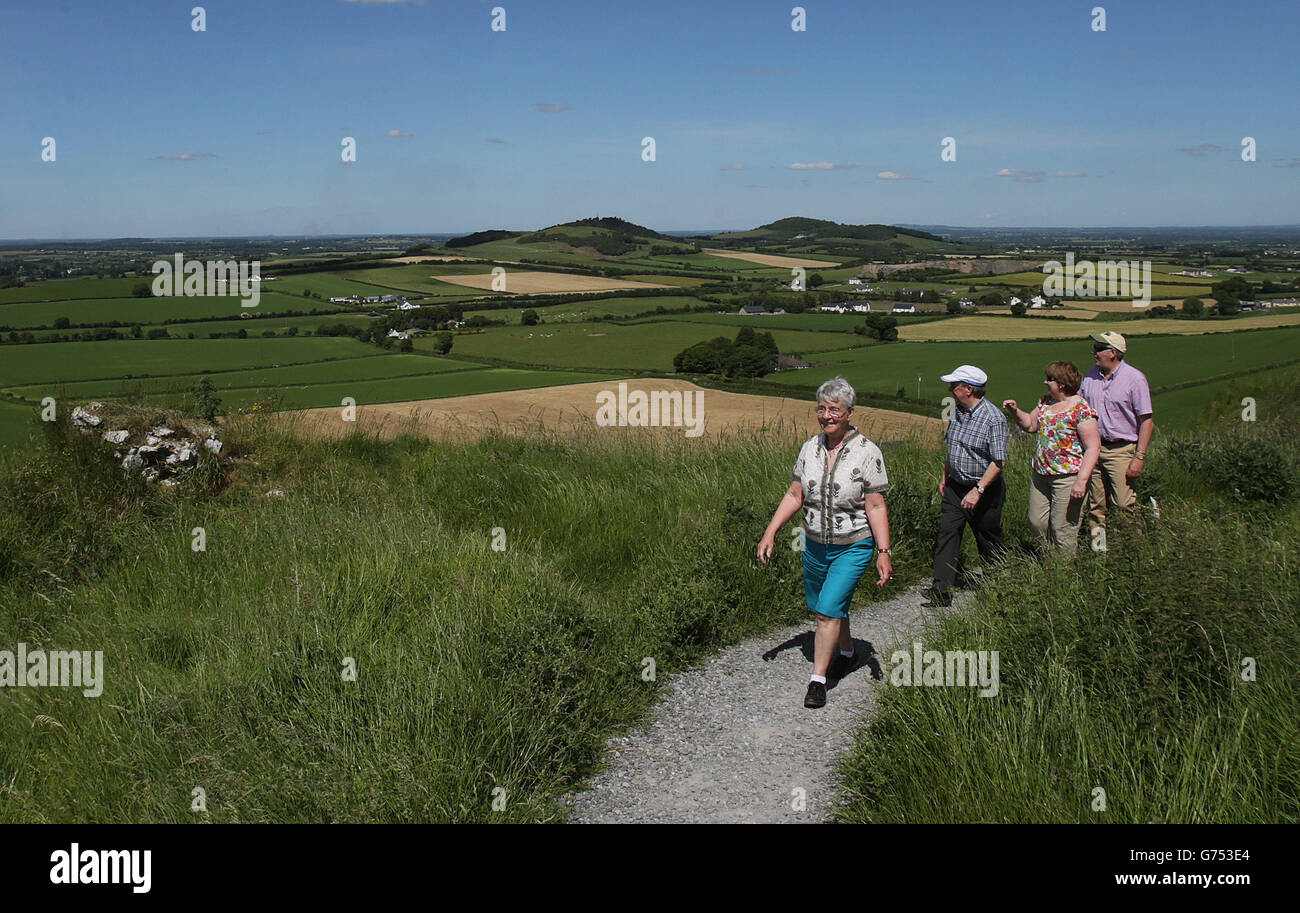 Hill walkers enjoy the view from The Rock of Dunamase, County Laois, during a period of hot weather. Stock Photo