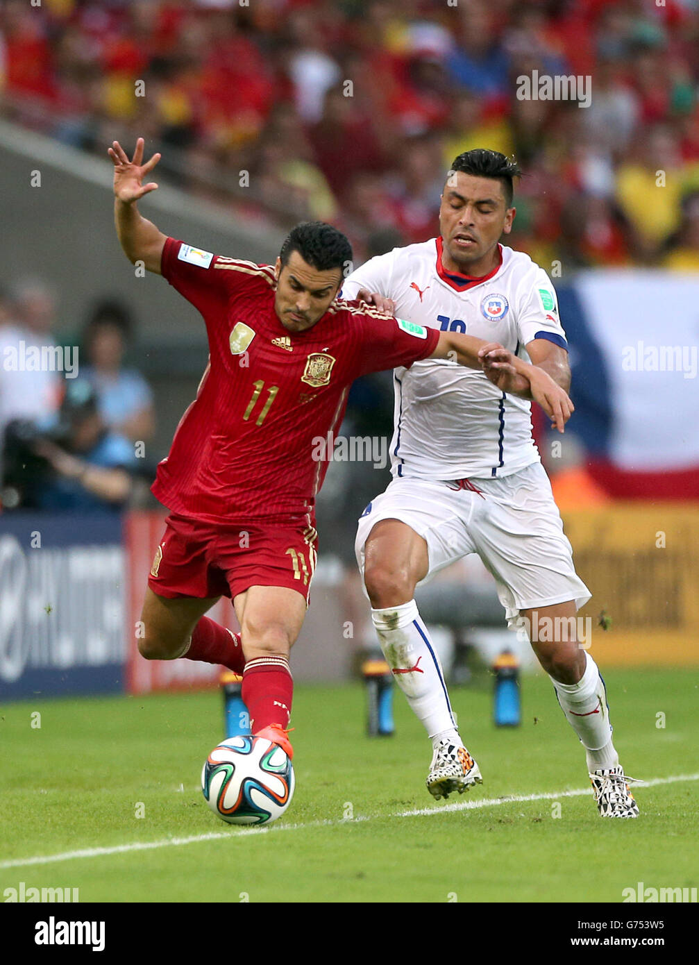 Soccer - FIFA World Cup 2014 - Group B - Spain v Chile - Maracana. Spain's Pedro (left) and Chile's Gonzalo Jara battle for the ball Stock Photo