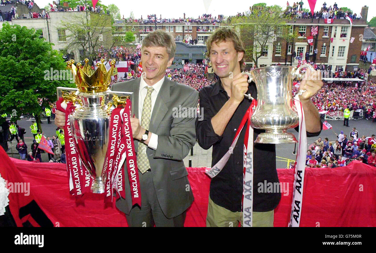 Arsenal's manager Arsene Wenger (left) and captain Tony Adams proudly hold the Premiership Trophy (with Wenger) and FA Cup, to thousands of their supporters. *The club's squad went to Islington Town hall, to a civic reception where they showed off the two trophies which were won in the last week. Stock Photo