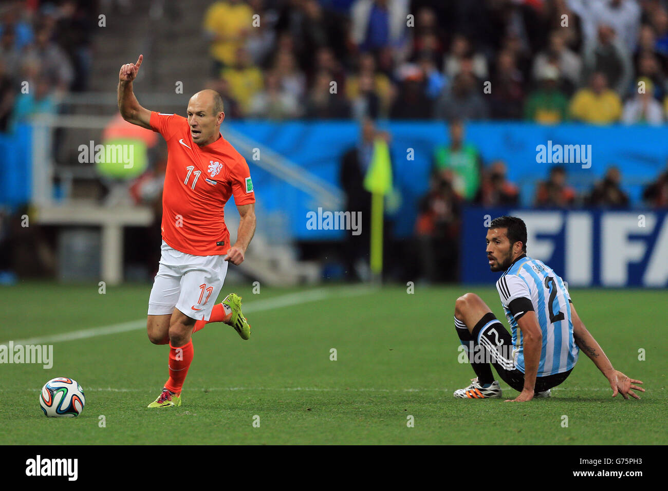 Netherlands' Arjen Robben runs past a challenge from Argentina's Ezequiel Garay Stock Photo