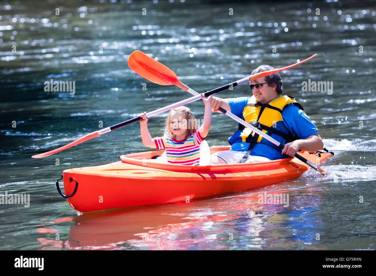 Family on kayaks and canoe tour. Father and child paddling in kayak in