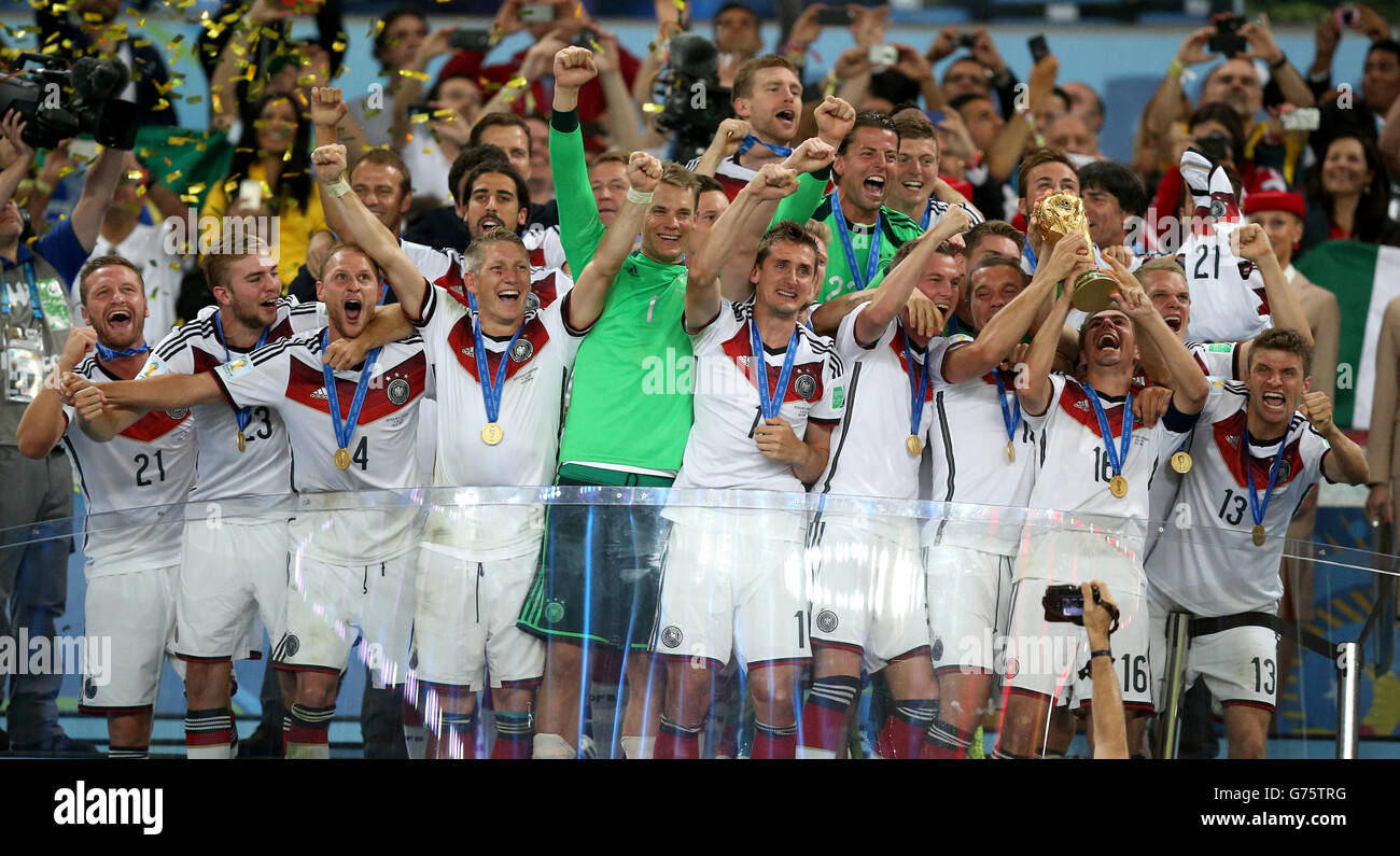 Germany's Philipp Lahm lifts the World Cup trophy as he celebrates winning the World Cup with team-mates after the FIFA World Cup Final at the Estadio do Maracana, Rio de Janerio, Brazil. Stock Photo